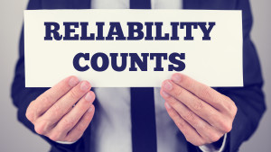 Close Up of Businessman Holding Sign Reading Reliability Counts.